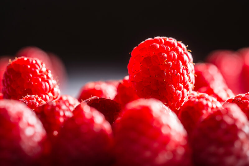 Himbeere auf einem Haufen Himbeeren liegend