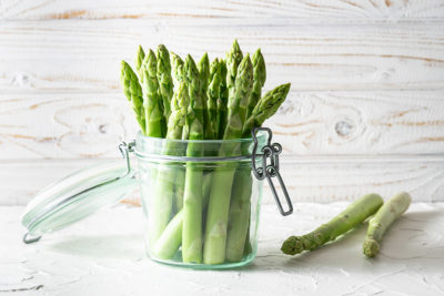 Grüner Spargel in einem Weckglas drapiert.