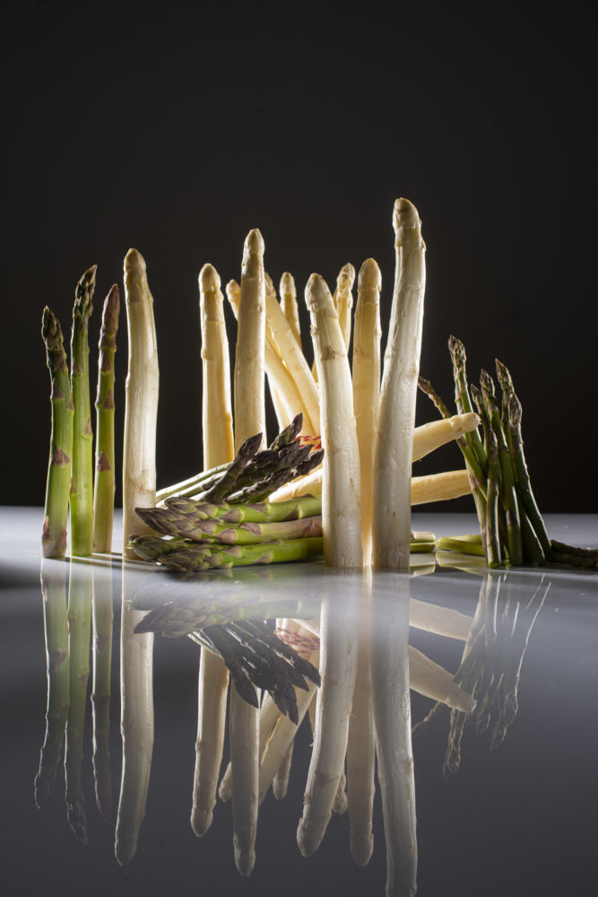 Grüner und weißer Spargel, teils liegend, teils stehend.
