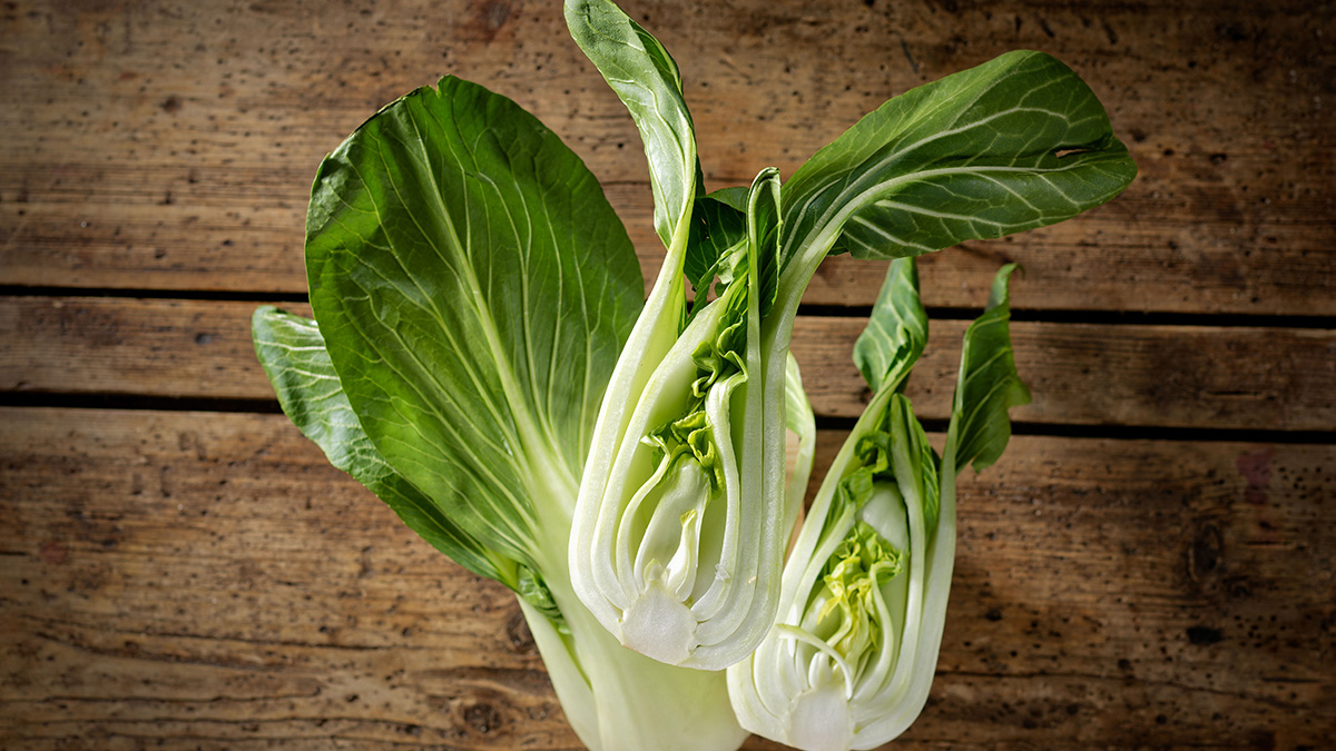 Pak Choi Angeschnittener, halbierter Pak-Choi vor ganzem Pak-Choi.